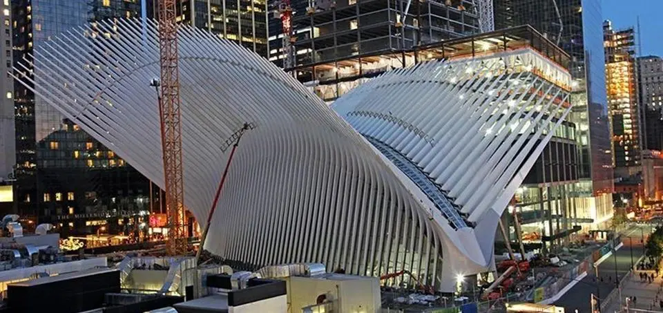 A building with a large roof and some construction in the background.