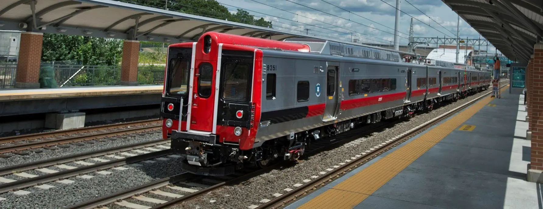 A red and silver train on the tracks.